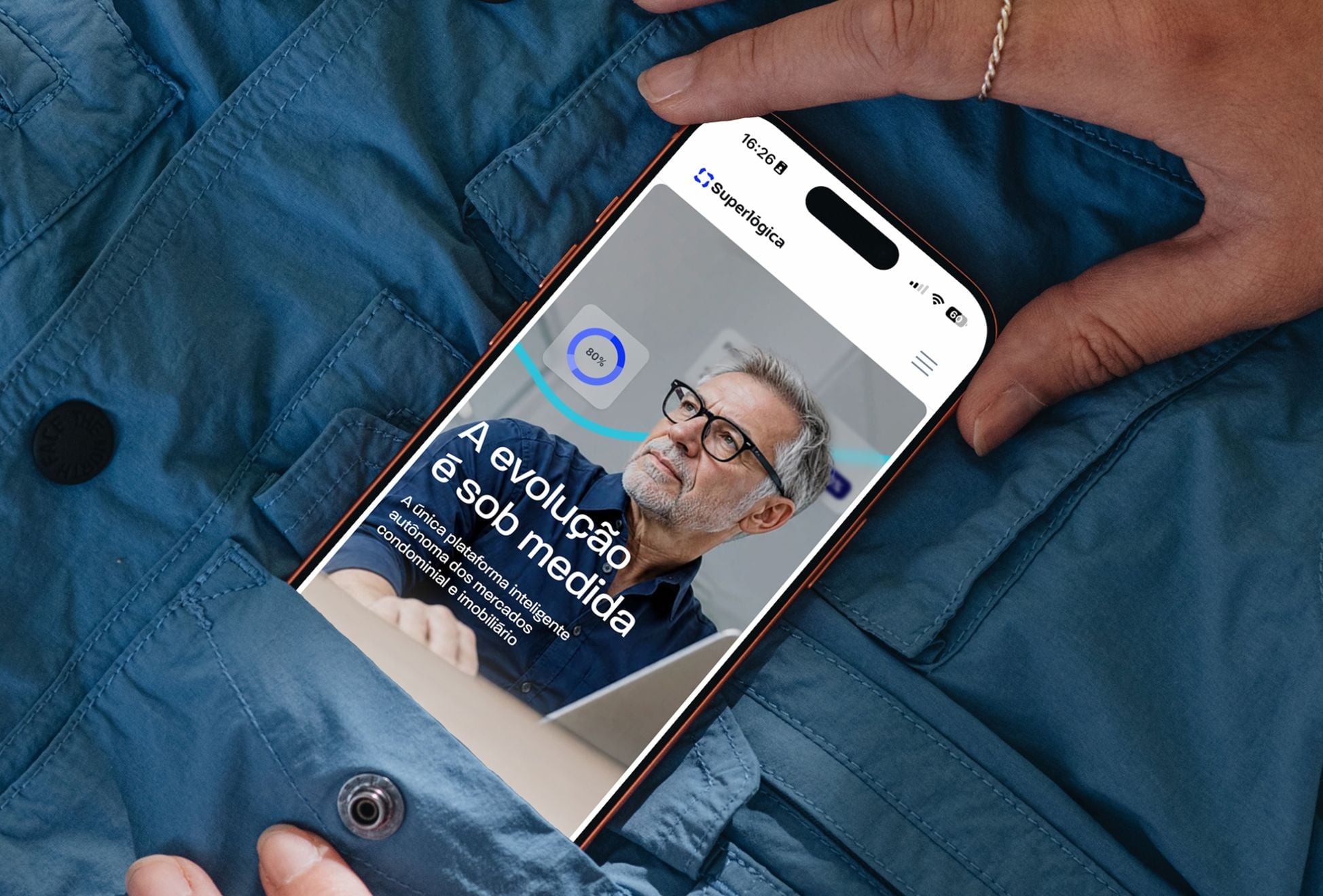 Superlógica — homepage no celular, em destaque nas mãos de uma pessoa